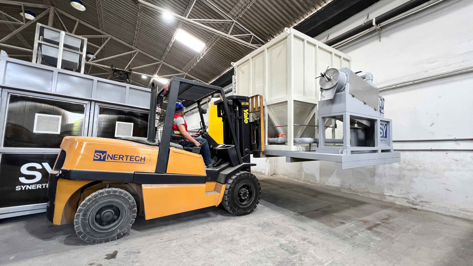 filtro multimedia azul siendo cargado por montacargas dentro de un contenedor para ser exportado